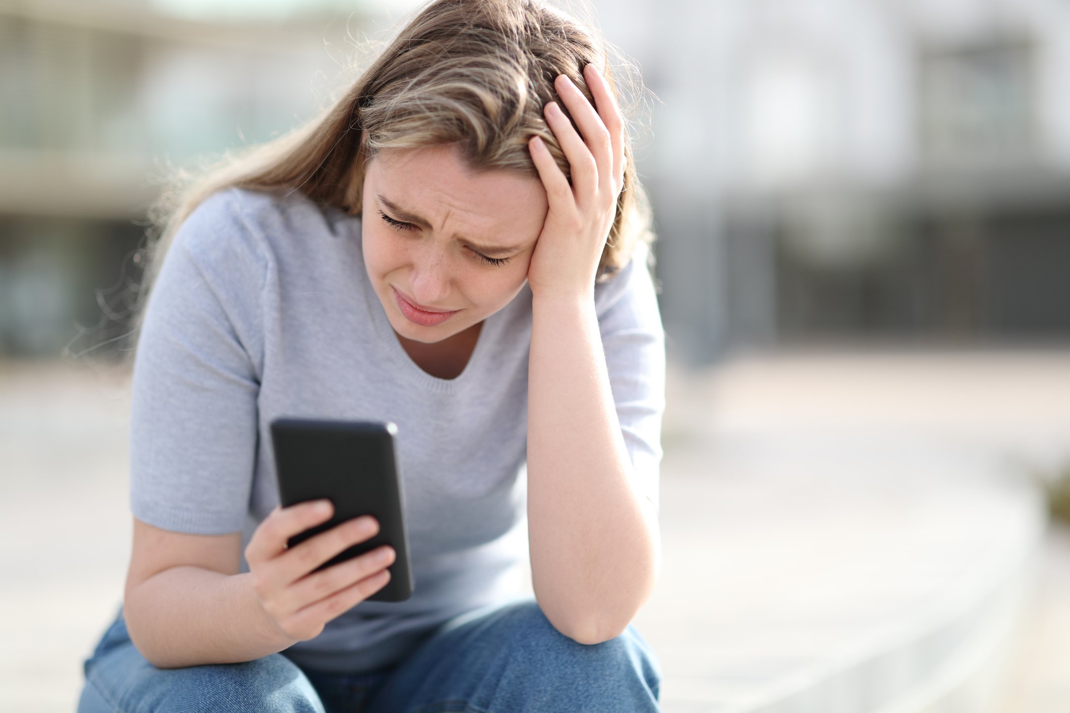 Sad person looking at phone