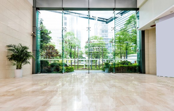 Inside of office building looking out at green park.