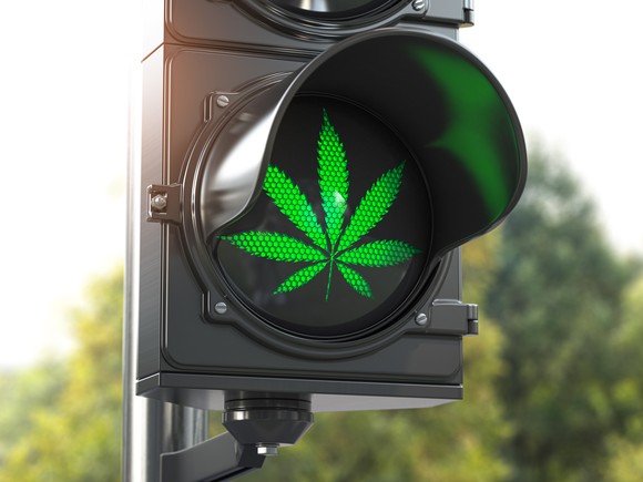 Green marijuana leaf on traffic light.