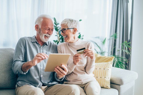 Couple smiling while making online payment