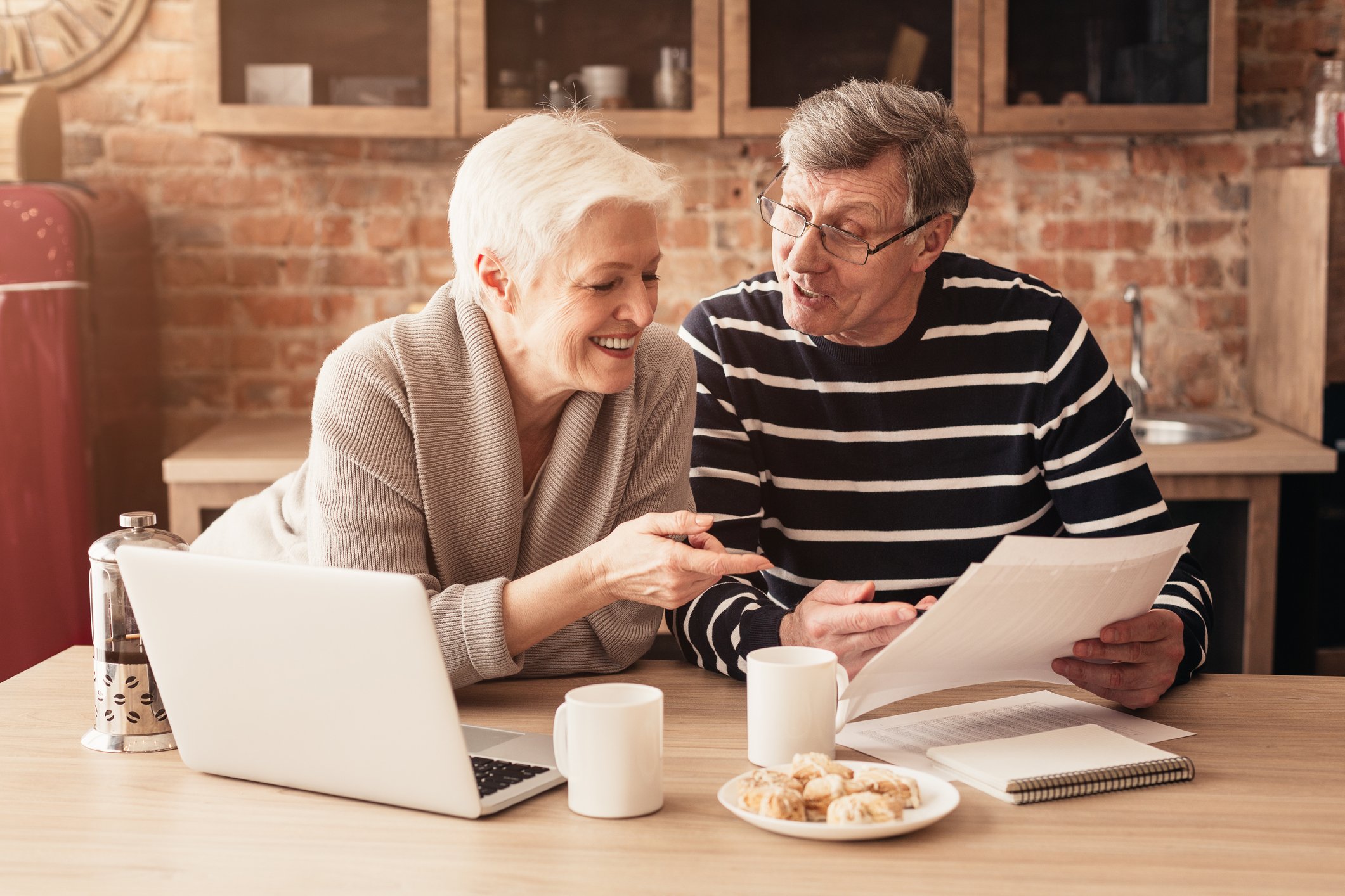Two older people reviewing paperwork.