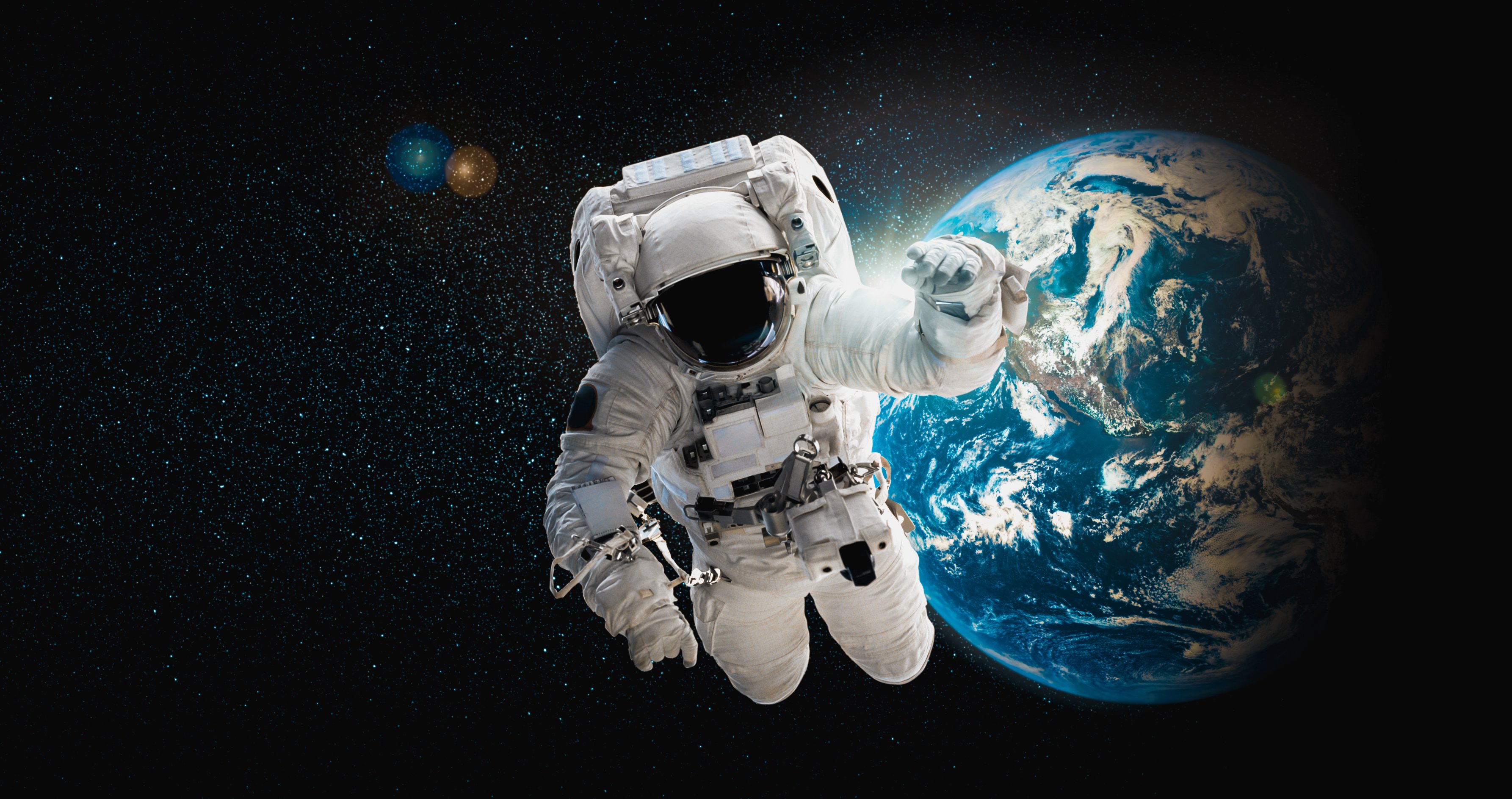 Astronaut in a space suit hovering in space over Earth.