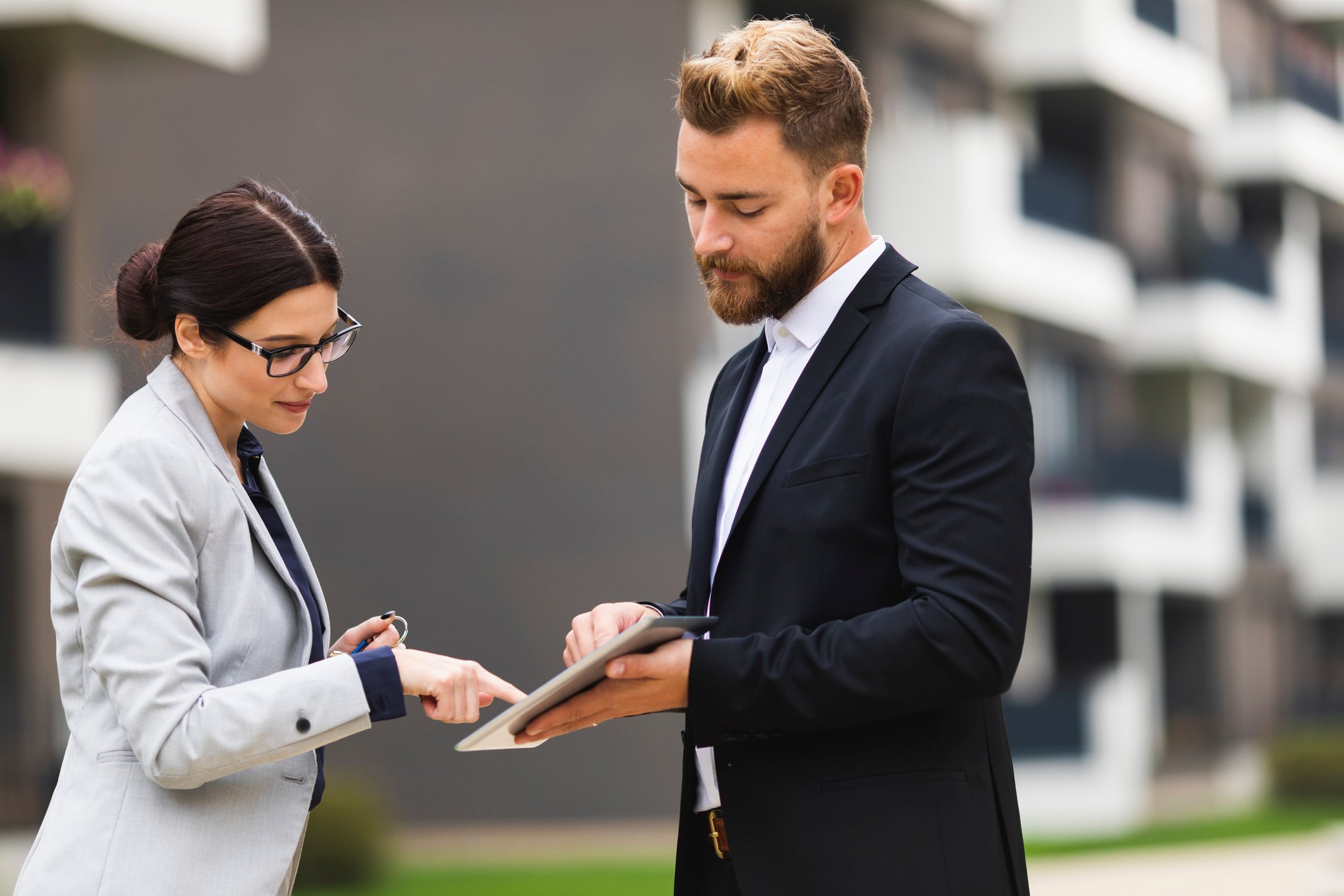 Two people agreeing to a digital contract on a tablet.