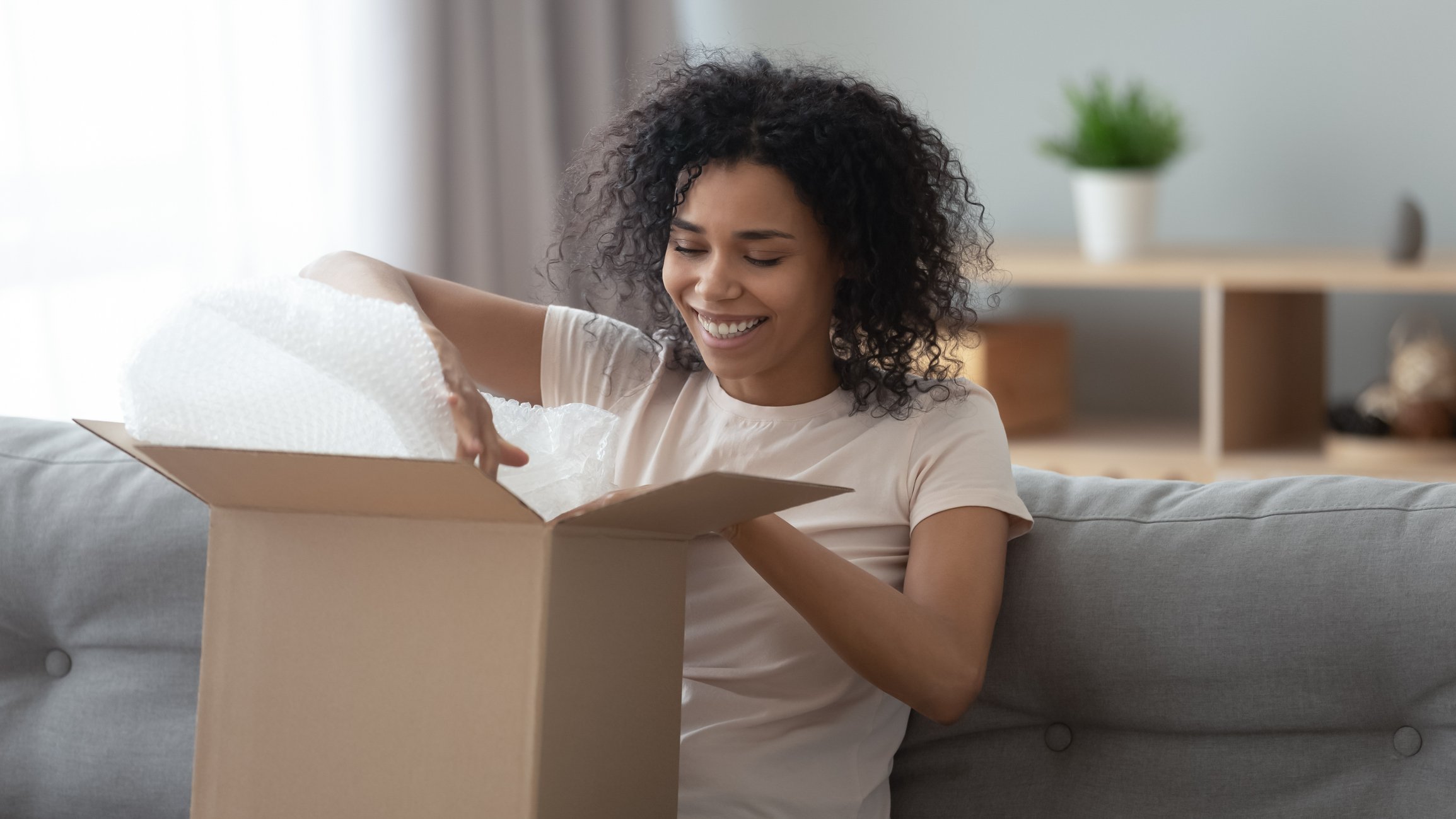 Person opening a package on the couch.