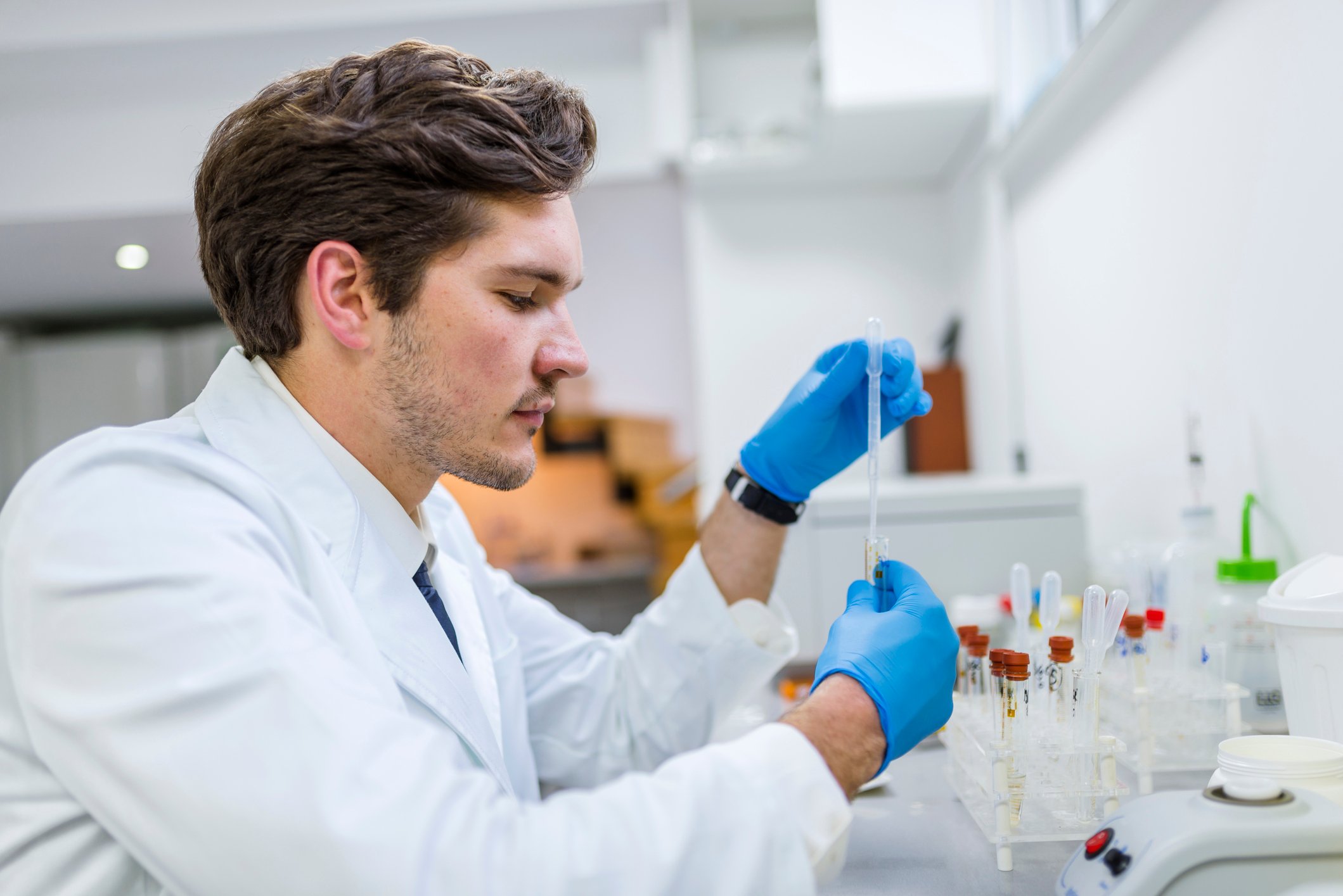 A scientist manipulates a liquid sample while working in a laboratory.