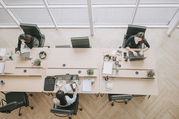 People working at a shared desk.