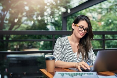 person works on laptop at outdoor cafe