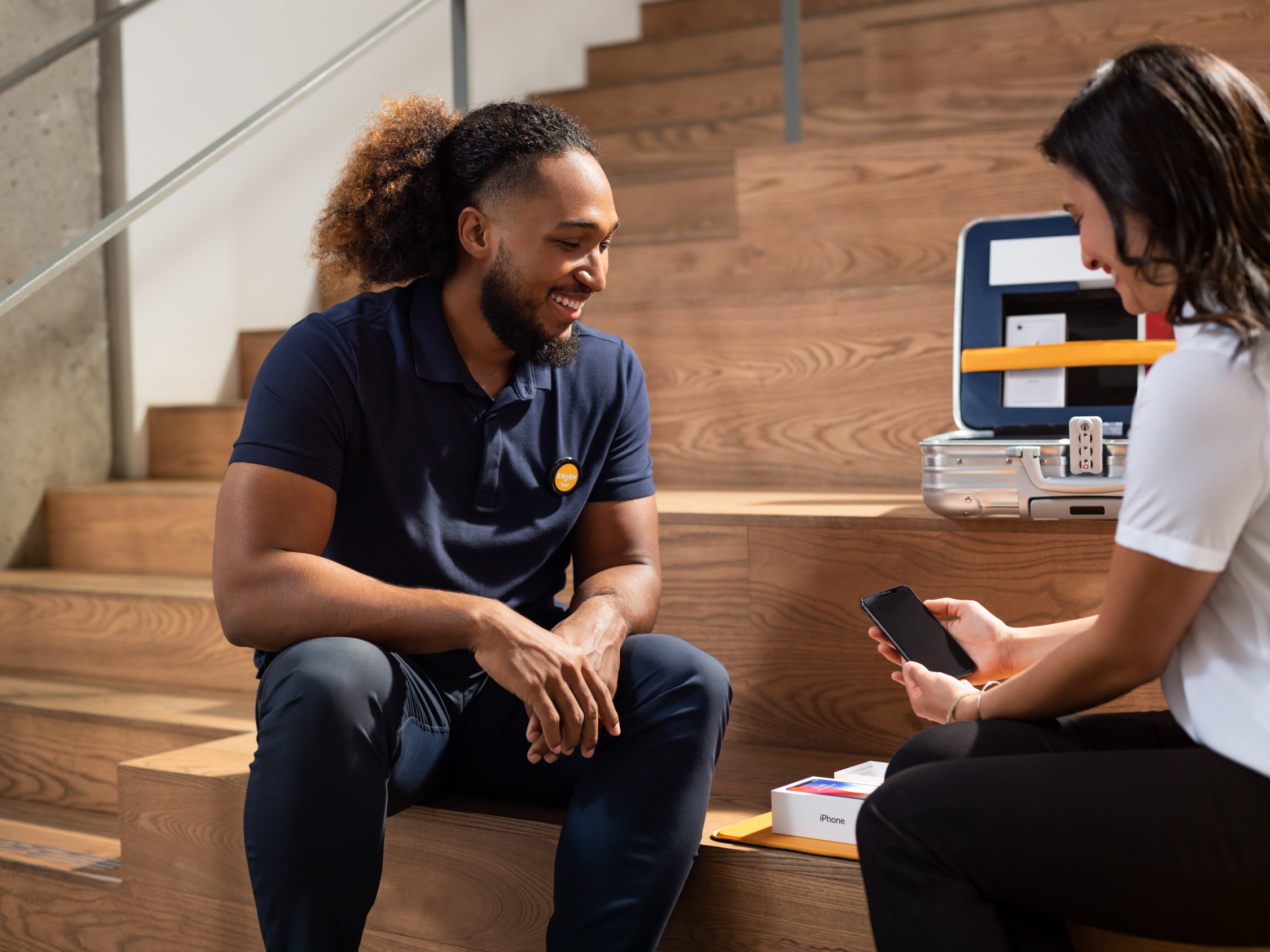 Enjoy Technology customer service person engaging with a customer in front of a set of steps.