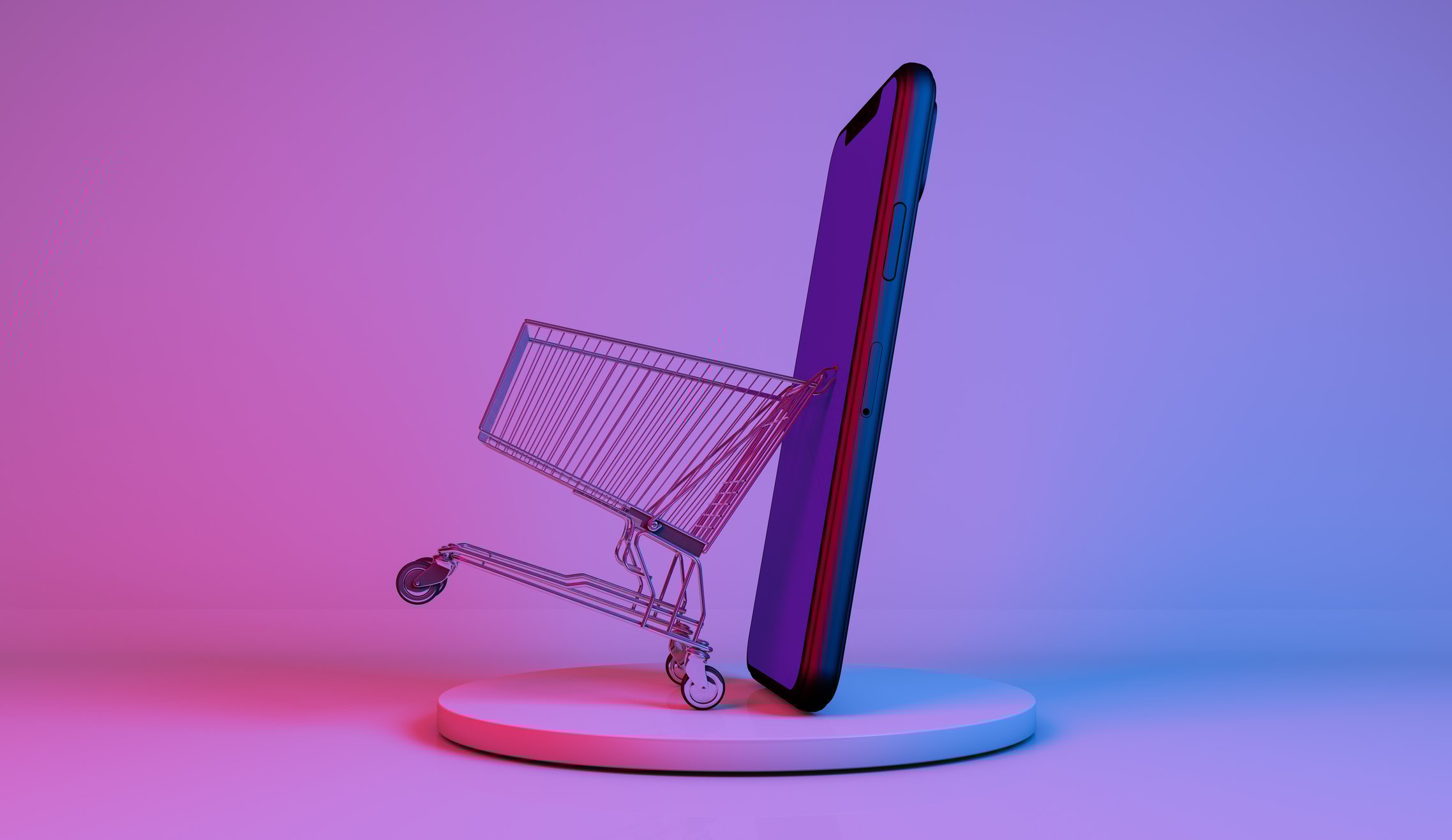 A miniature shopping cart next to a phone.