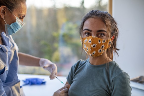 A healthcare professional giving a shot to a person.