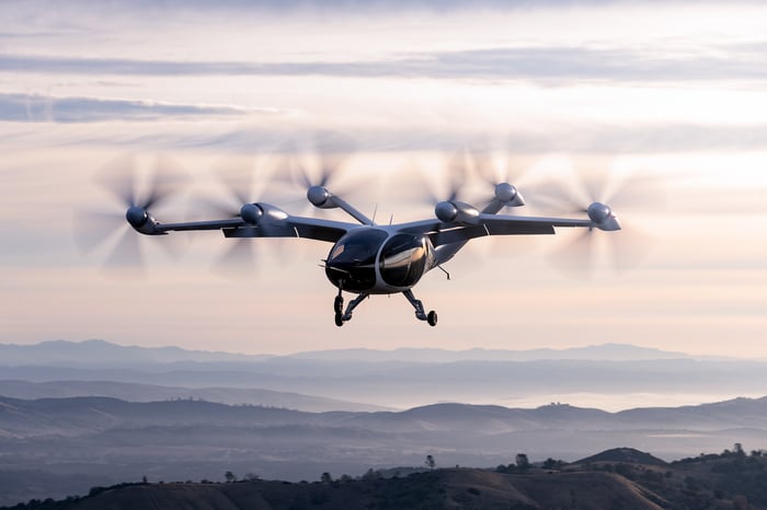 Joby's aircraft hovering over a mountain landscape.