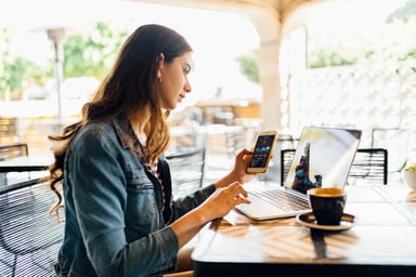 person working on laptop outside coffee shop