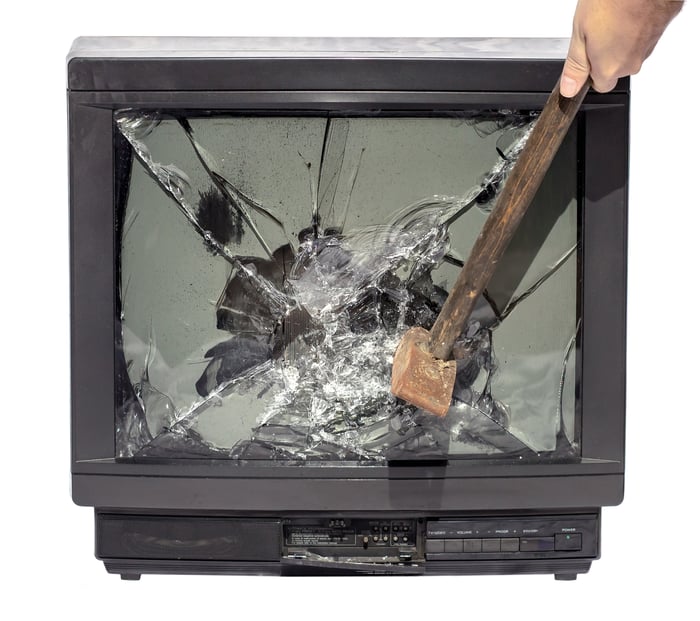 A hammer smashing a television screen. 