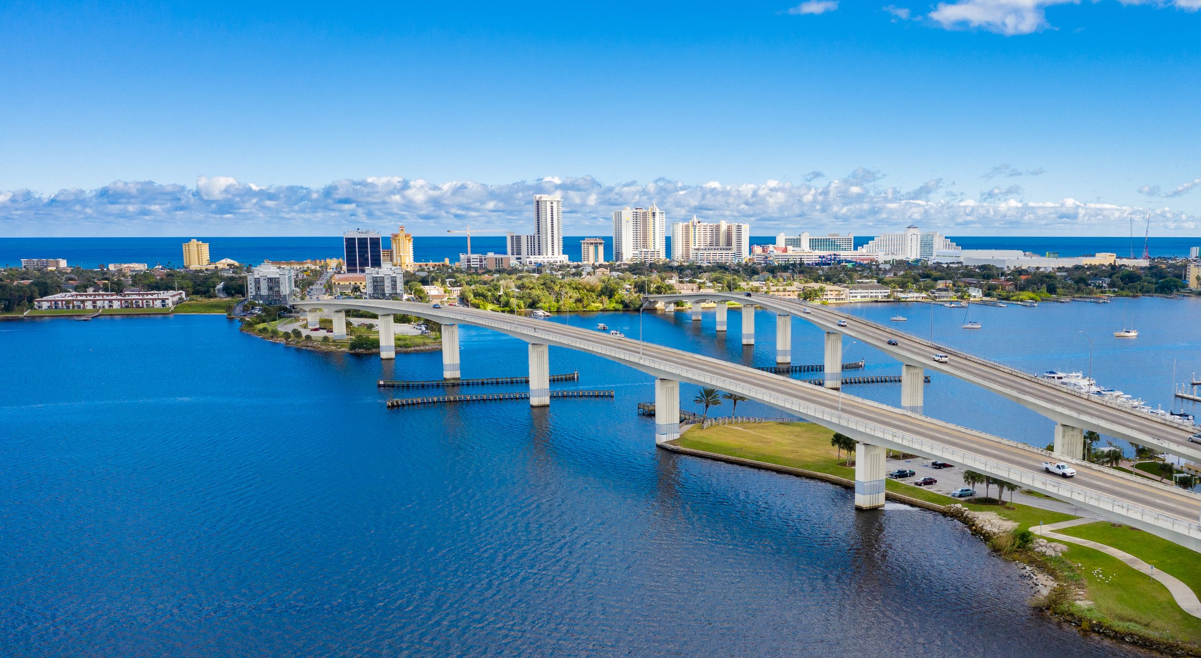Aerial shot of beachfront city with two bridges.