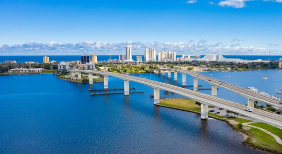 Aerial shot of beachfront city with two bridges.