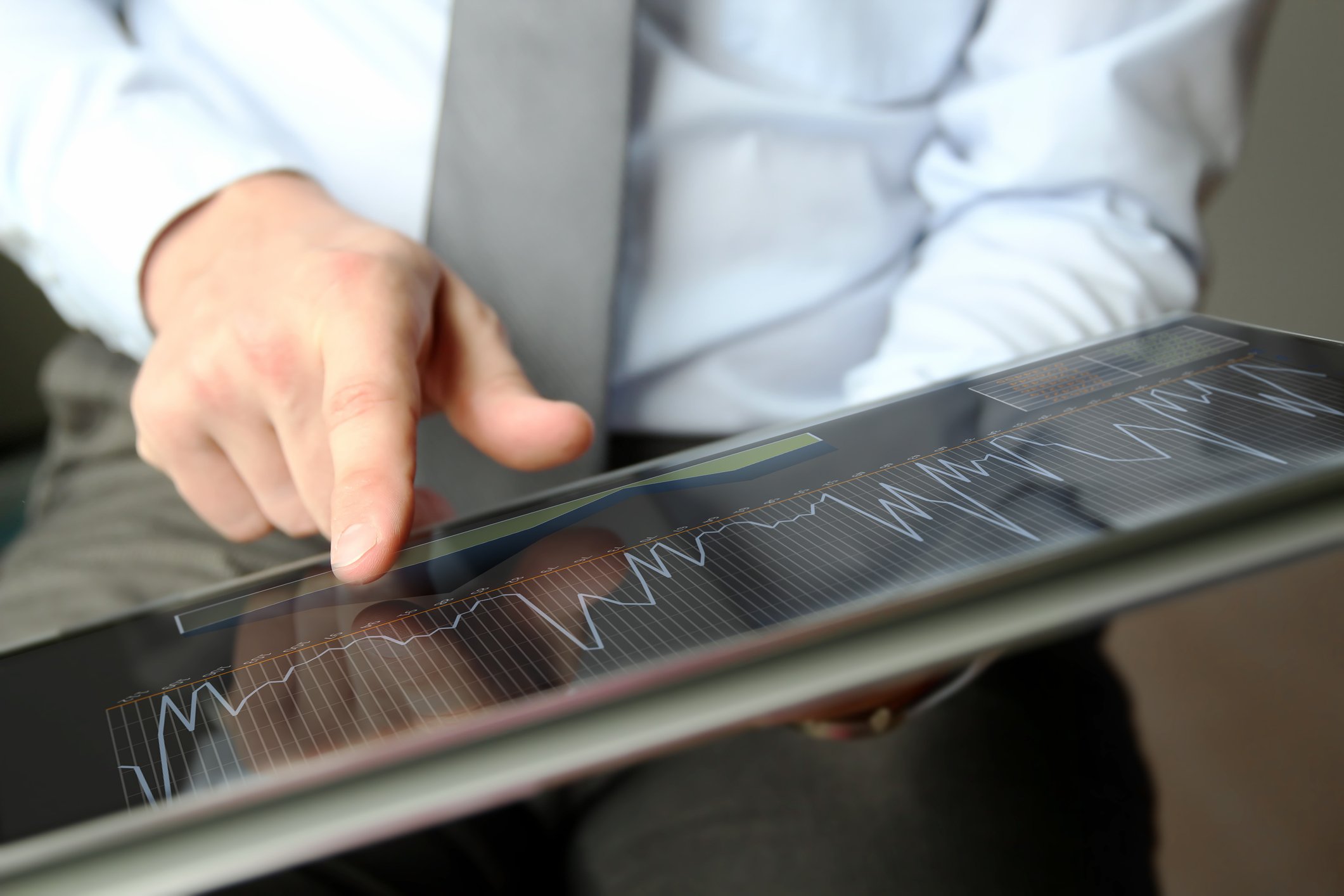 Person pointing at a chart on a tablet.