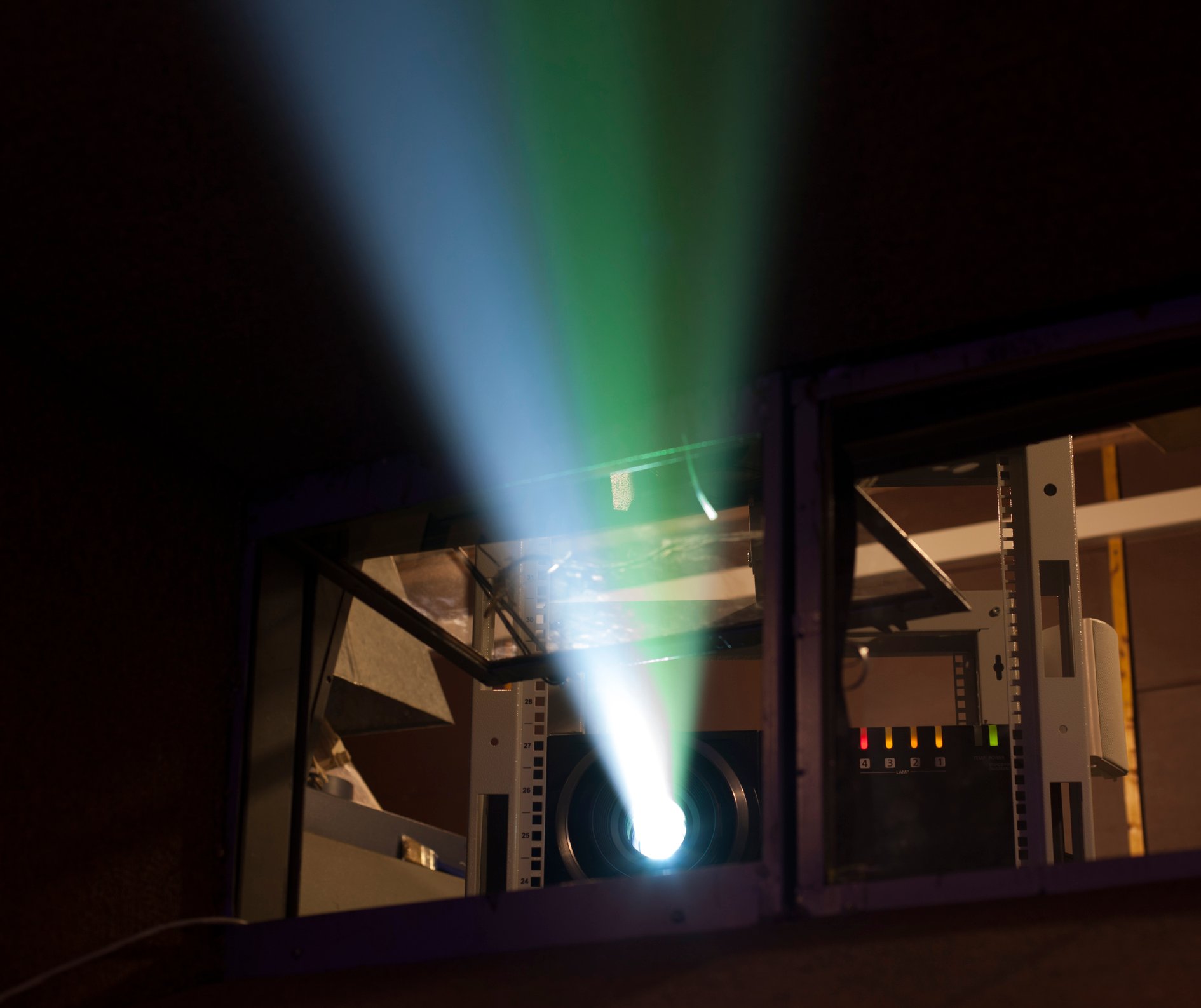 Movie theater projection booth with light beam.