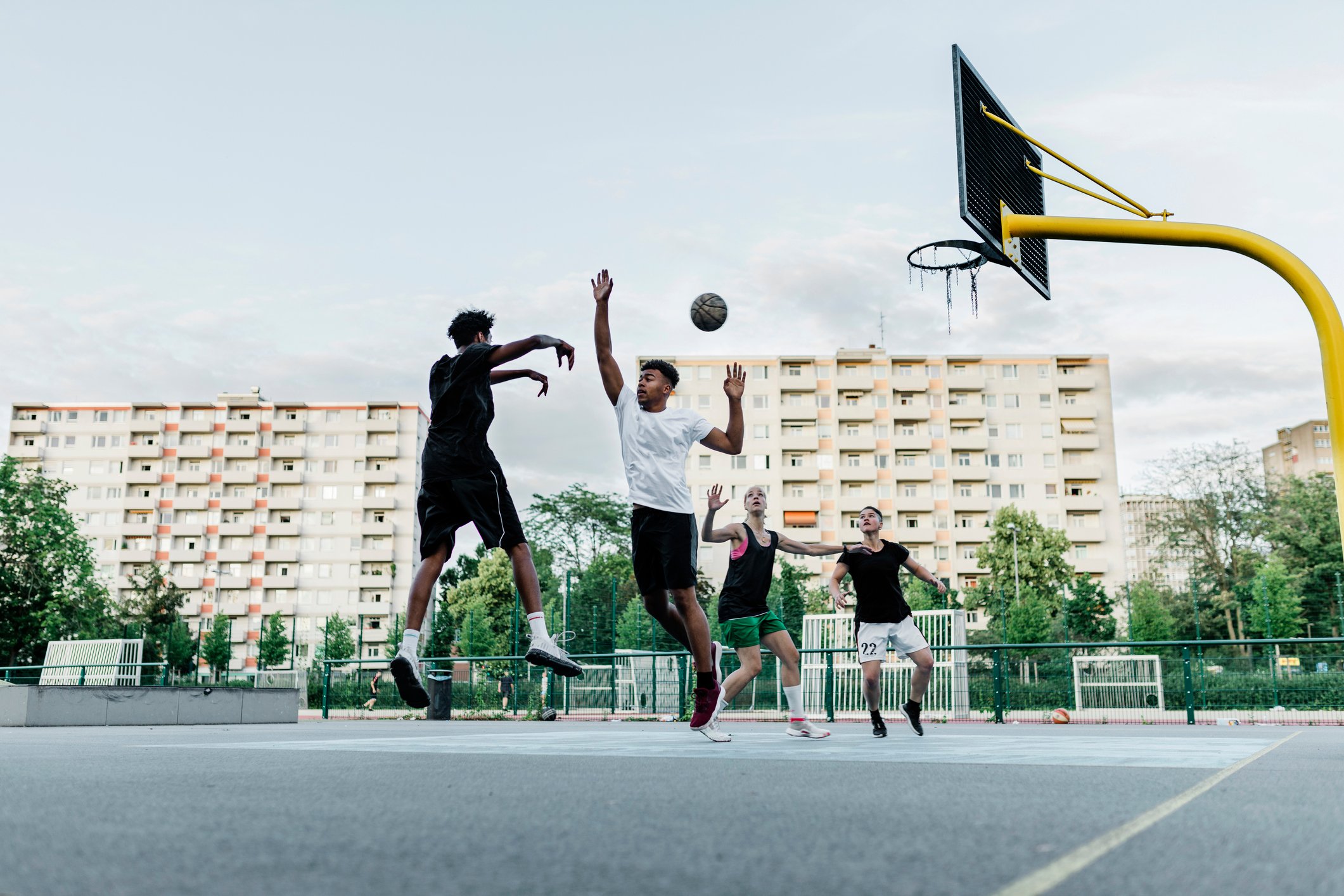 Athletes jumping during a 2 on 2 game of pickup basketball.