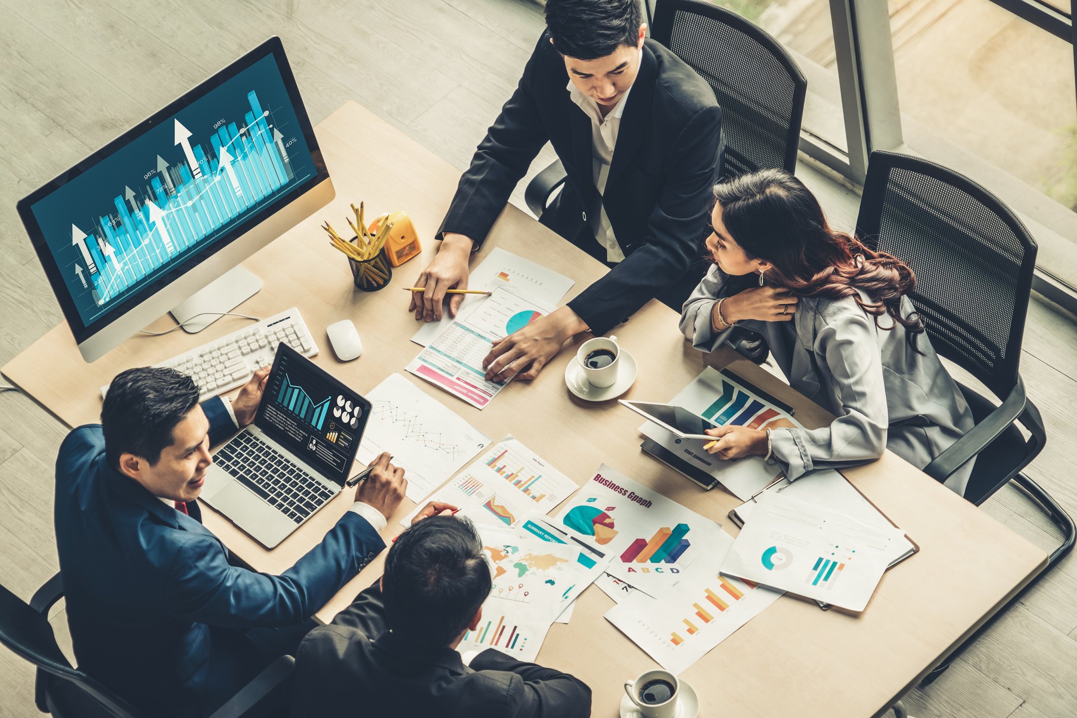 A team of co-workers review business data at a table.