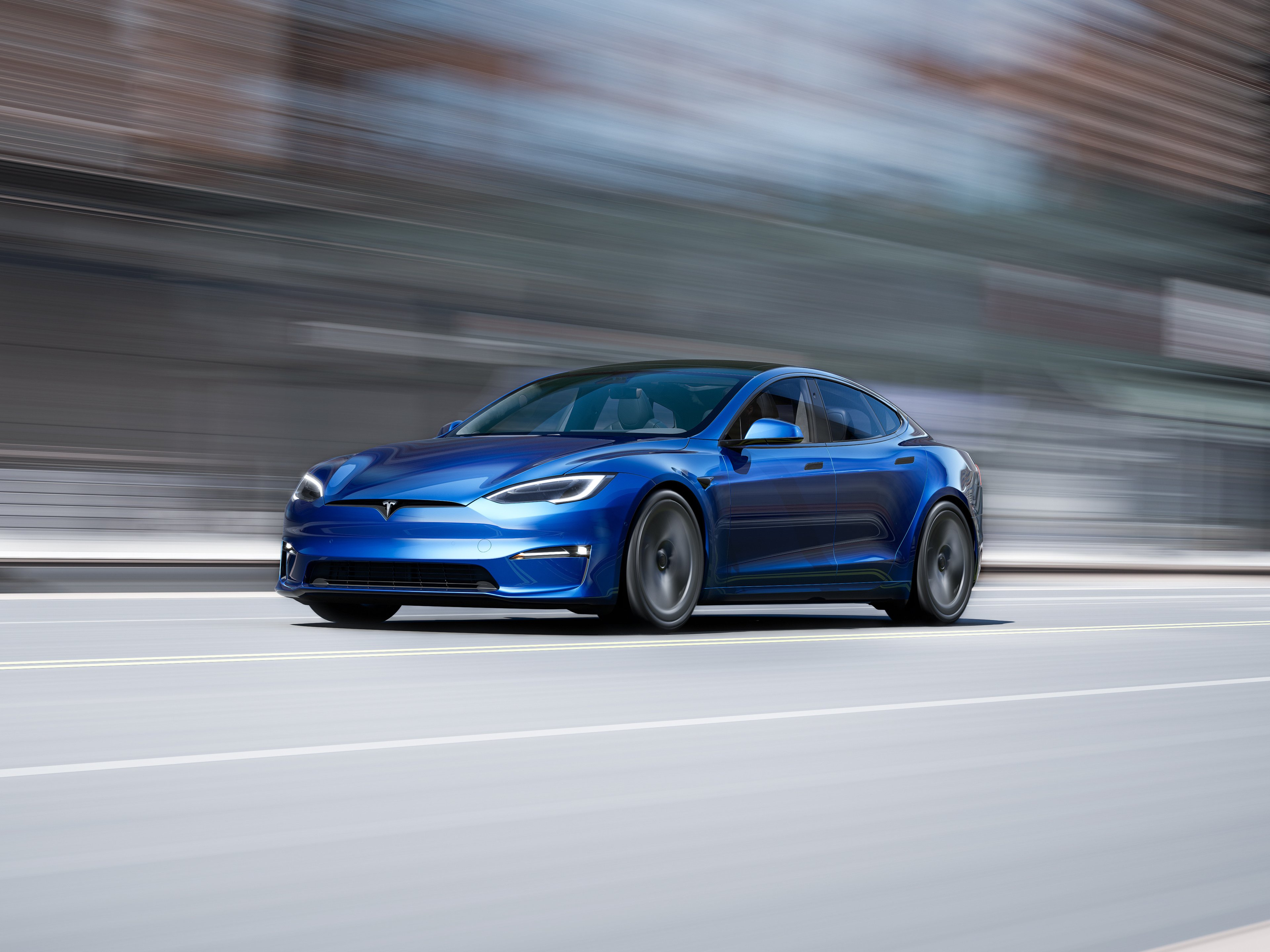 A Tesla Model S moving at a high rate of speed causing blurring of the background.