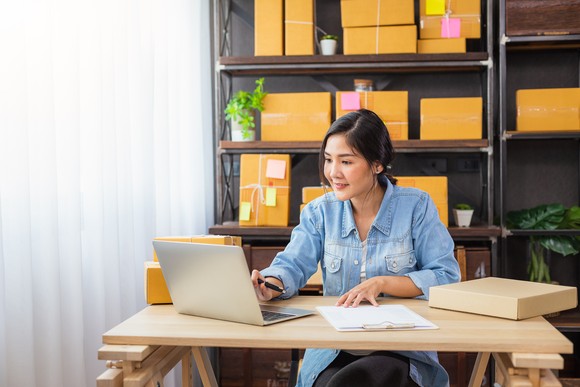 An online merchant processes orders on a notebook computer.