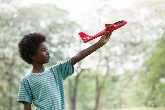 A boy plays with a toy plane.