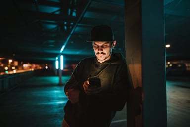 person using mobile phone outdoors at night