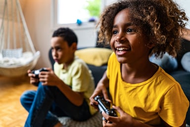 2 children playing video games at home