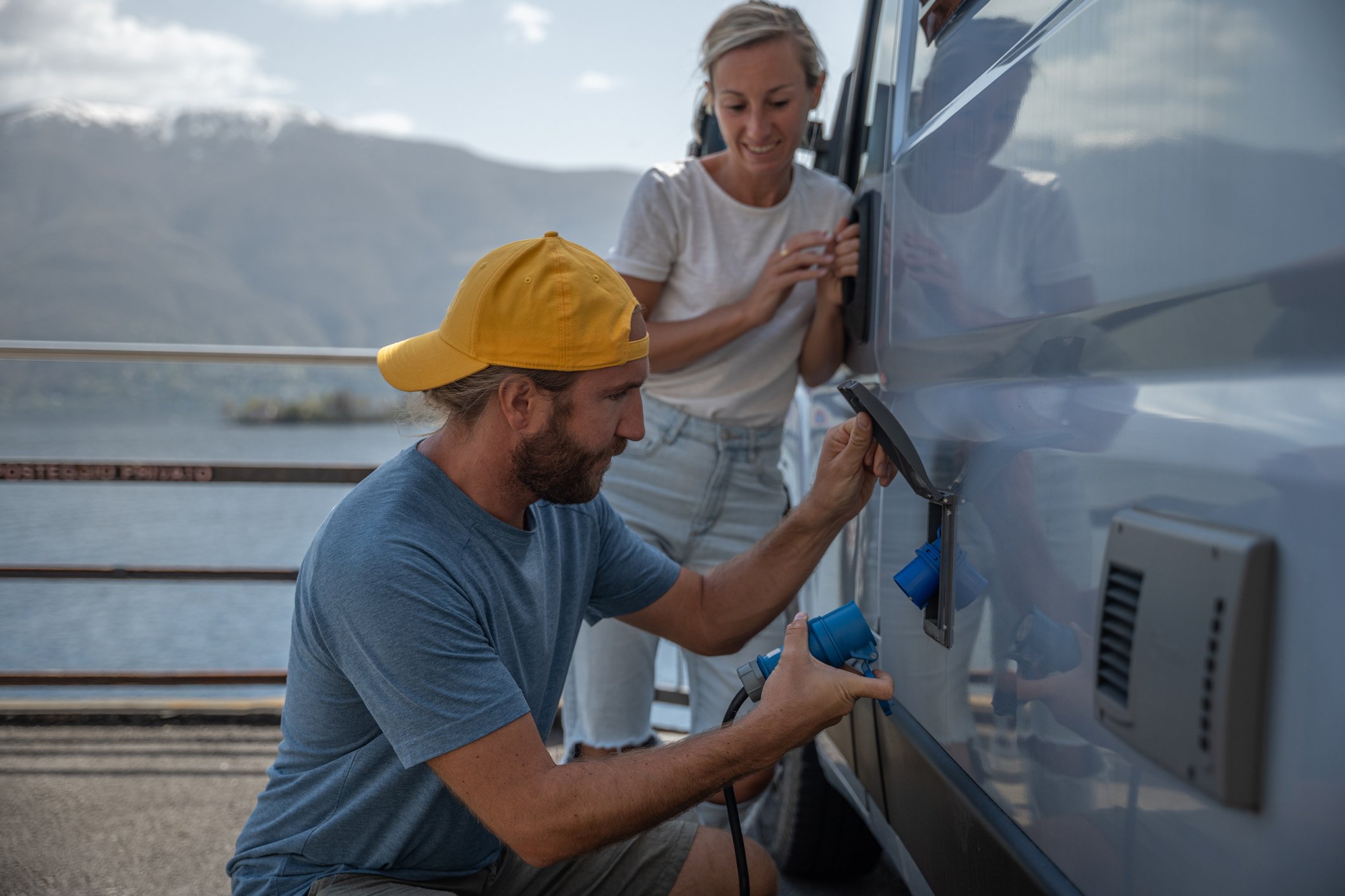 A couple hook up camper to electric outlet.