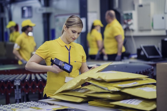 People processing packages in a postal or similar facility.