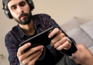 person playing mobile game at home