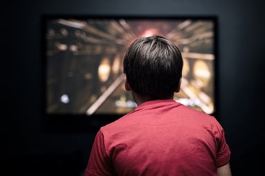 back of person watching TV screen