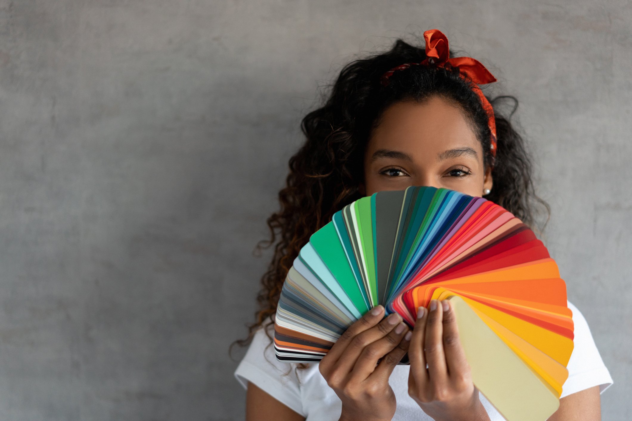 A young person looking over a palette resembling a fan of colors.