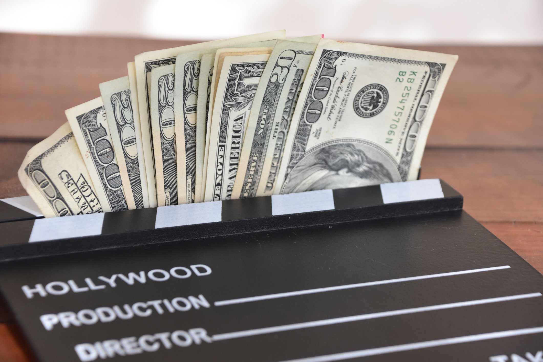 Money held in movie set clapboard.