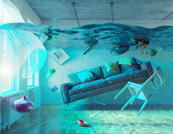 A room full of water with furniture floating.