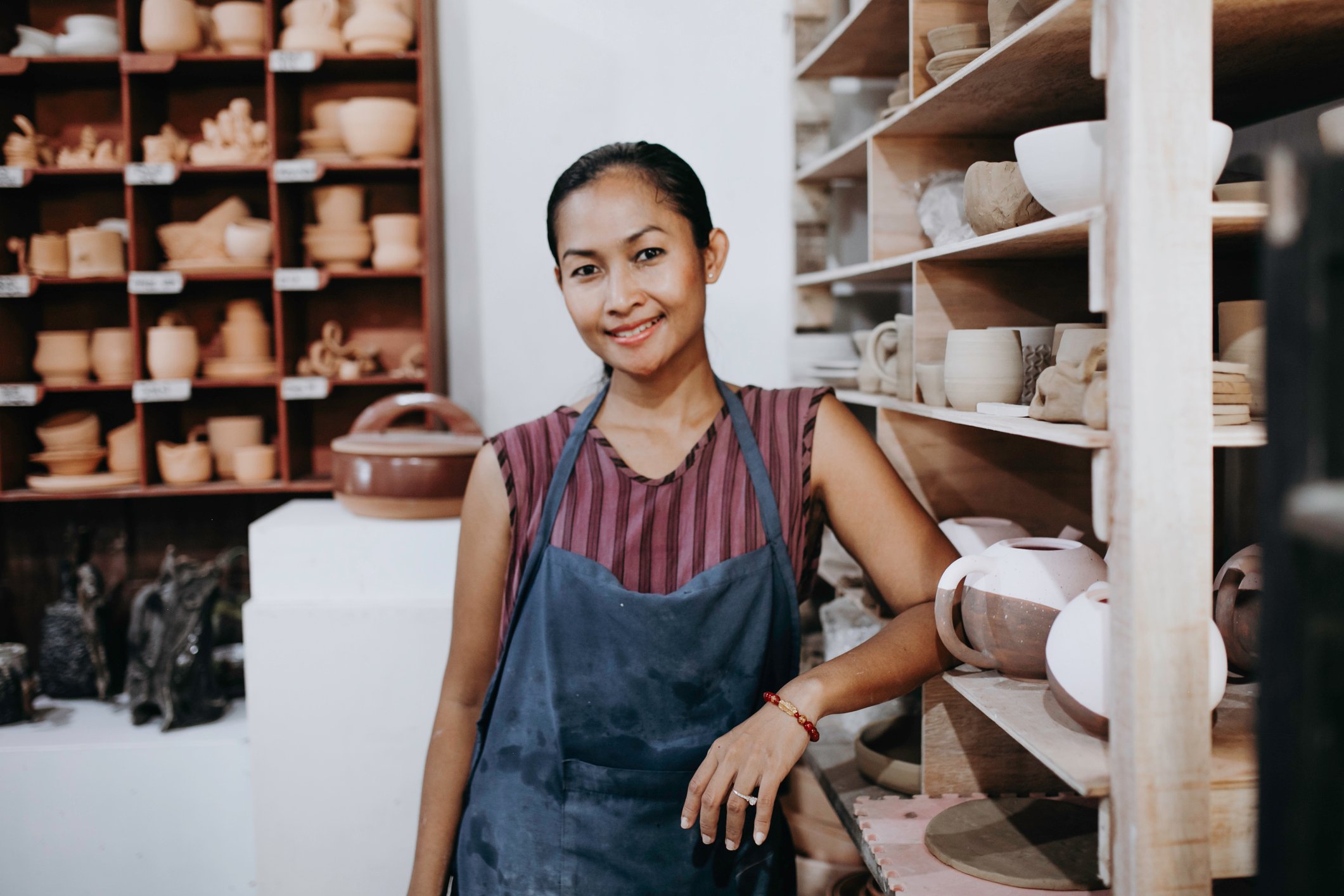 A smiing worker at a pottery shop.