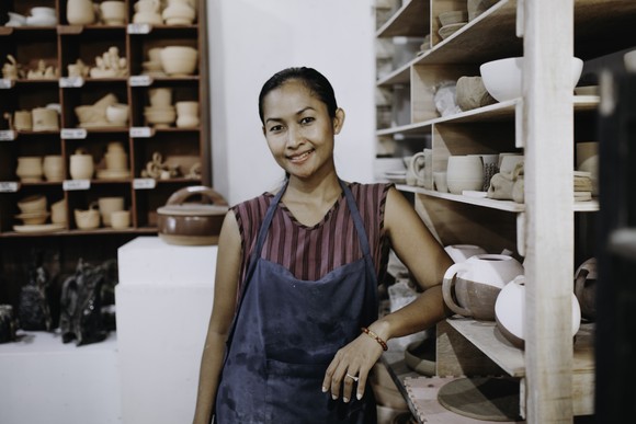 A smiing worker at a pottery shop.
