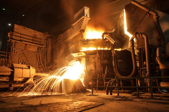 electric arc furnace (EAF) melting scrap into steel with sparks. 