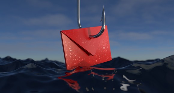 A red envelope with a hook through it as it dangles over the ocean.