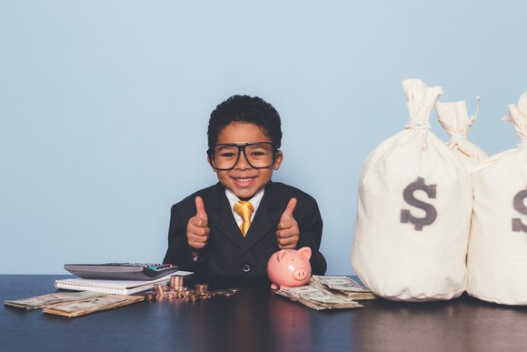 A child counting bags of money.