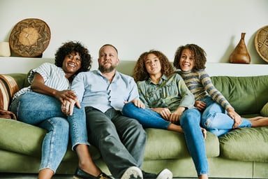 A family sitting on a couch watching TV