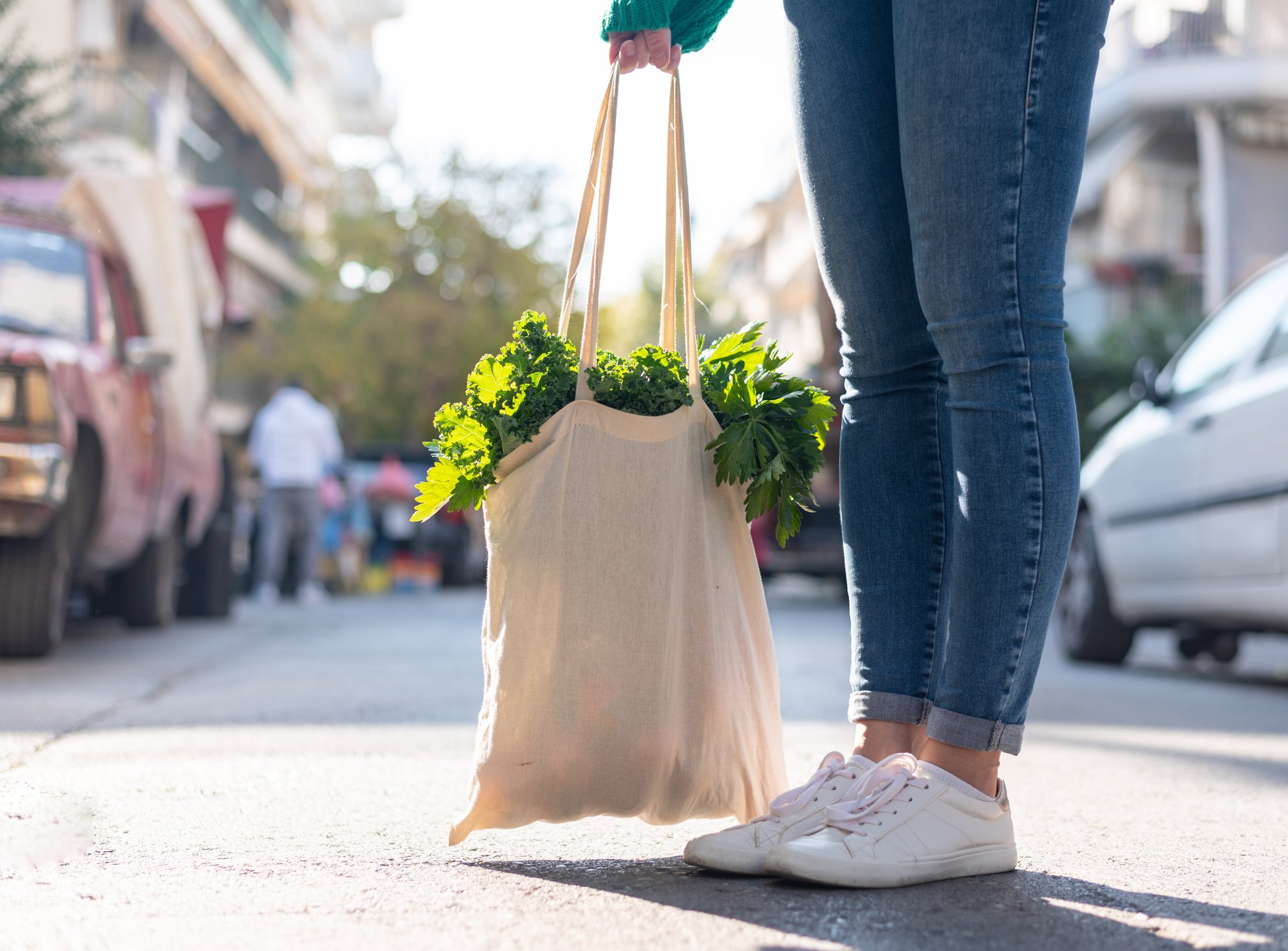 Person in sneakers holding a bag