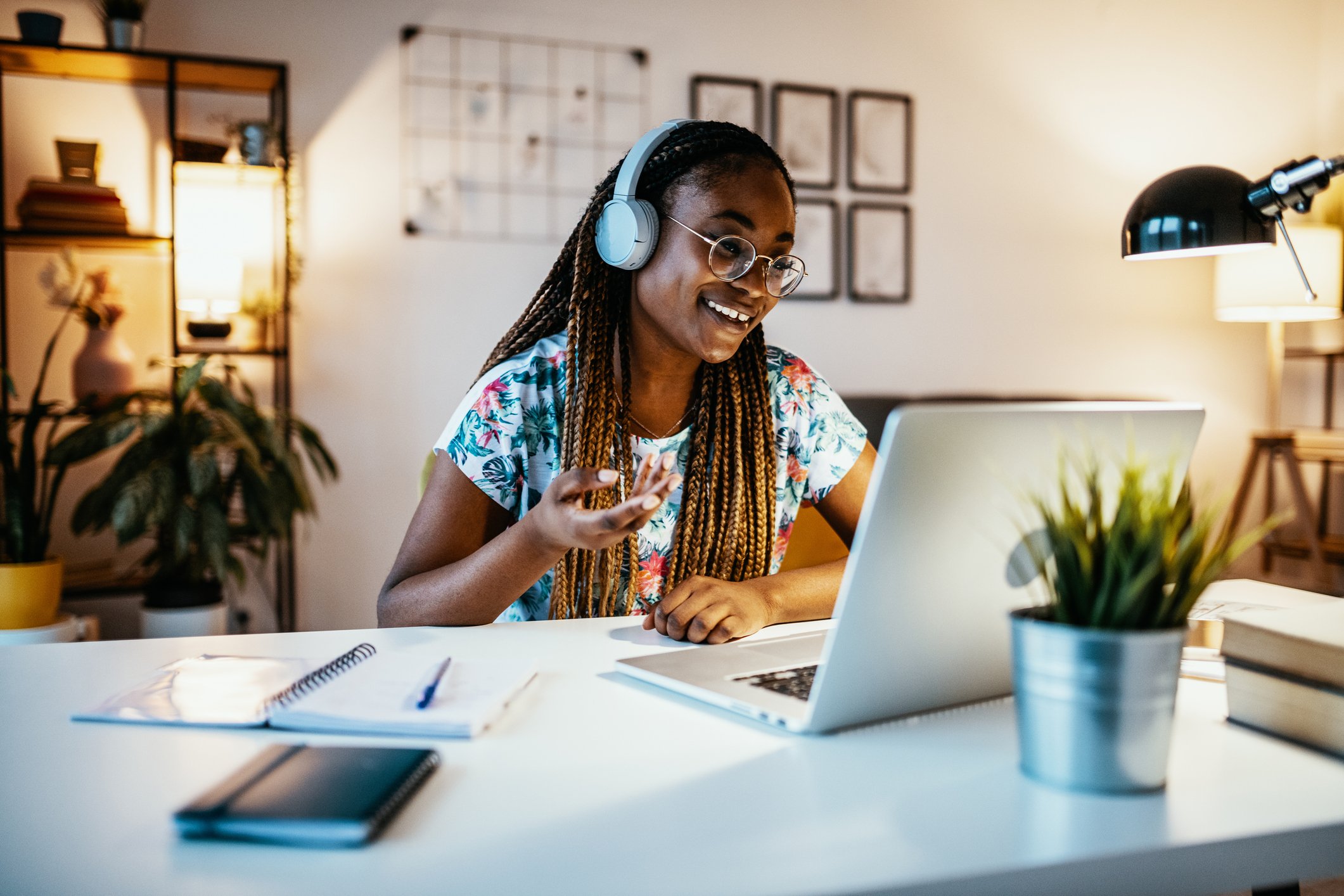 Person smiling, wearing headphones, using laptop.