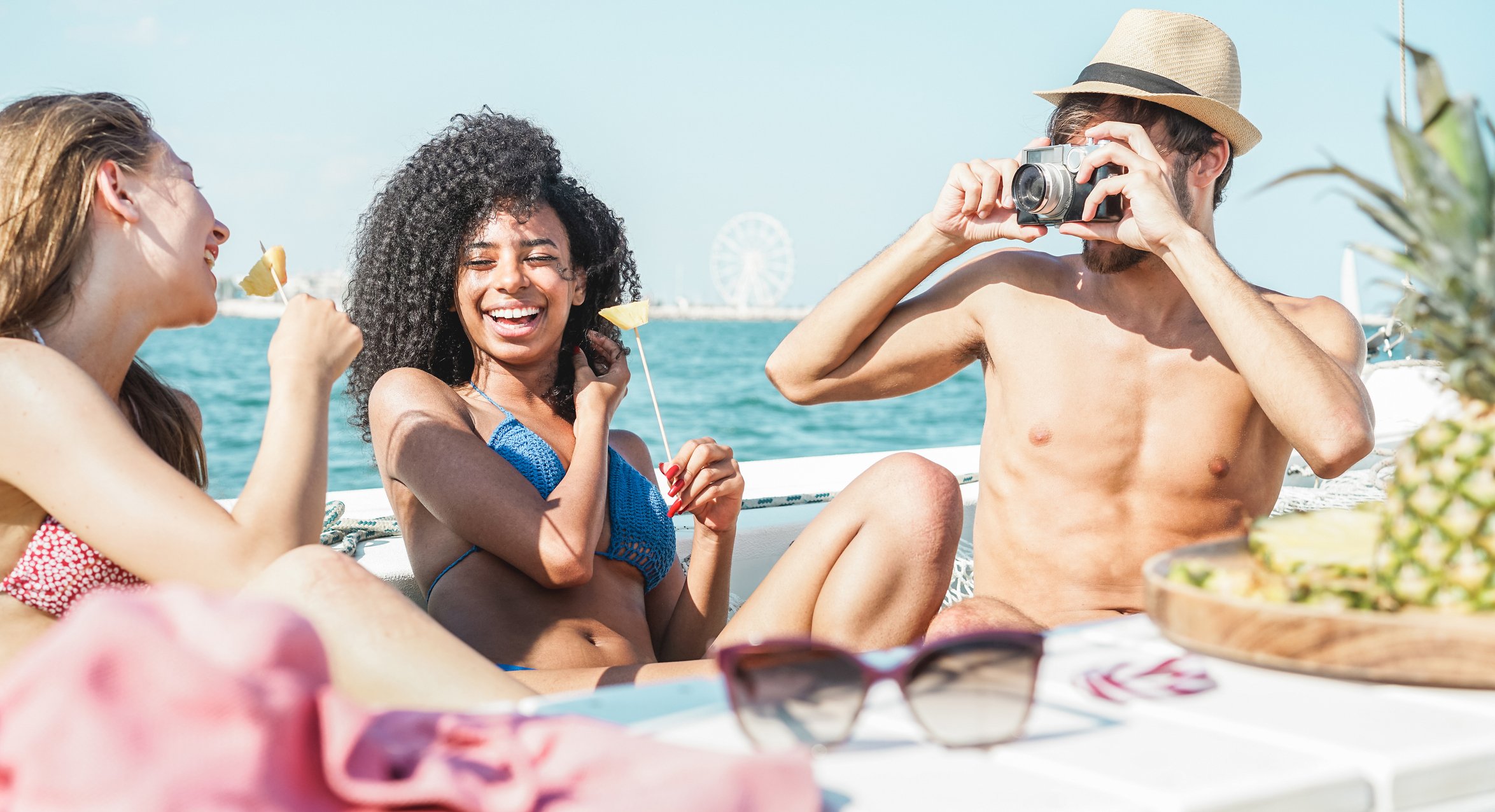 Three people on a boat smiling and taking pictures.
