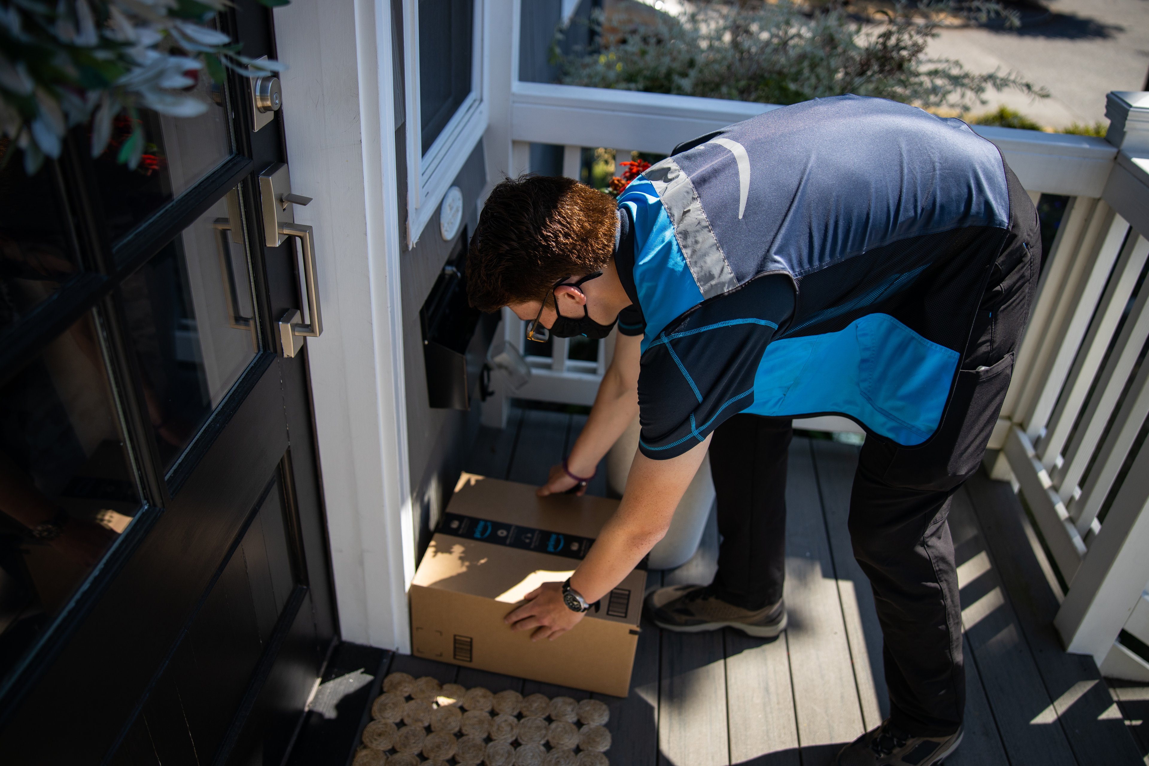 Amazon delivery person leaving package at door.