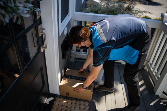 Amazon delivery person leaving package at door.