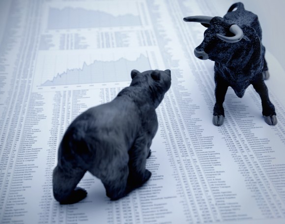 Bear and bull squaring off over stock pages.