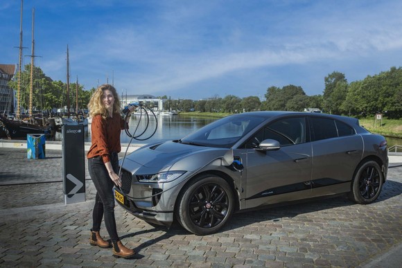 EV owner plugging car into Allego charger. 