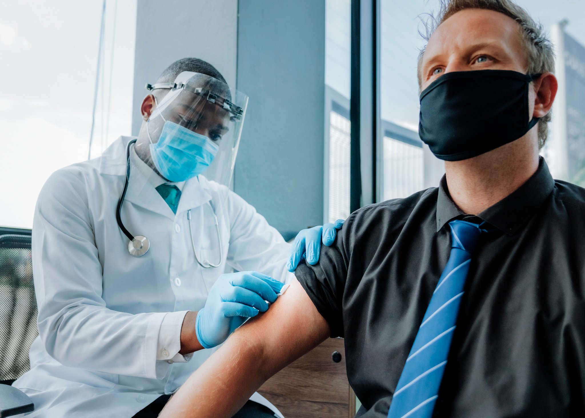 Person receiving a vaccine shot from a medical professional.