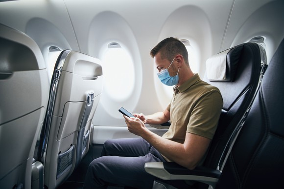 A passenger using a smartphone on an airplane.